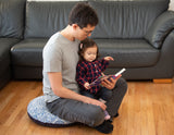 Man on floor cushion reading to child